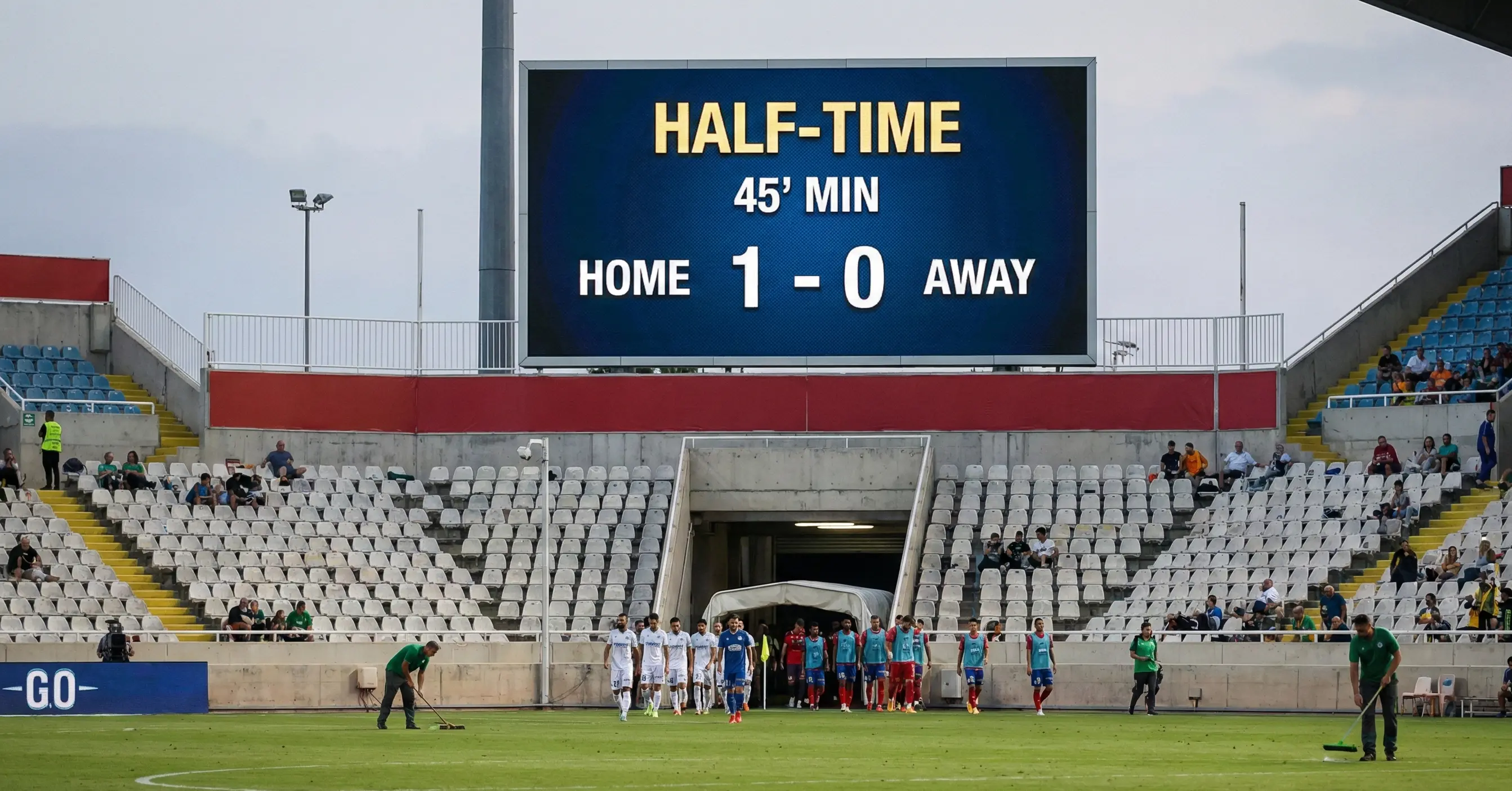Stadium scoreboard showing halftime score with teams heading to locker rooms
